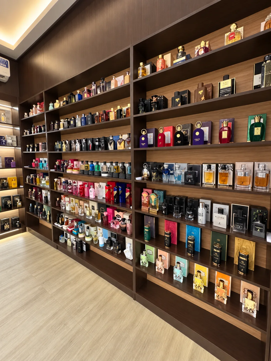 Exposição de perfumes nas estantes de madeira do showroom